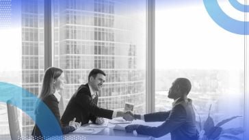 A job candidate shakes hands with two interviewers