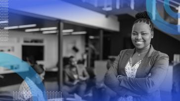 A smiling and successful Black woman in a workspace.